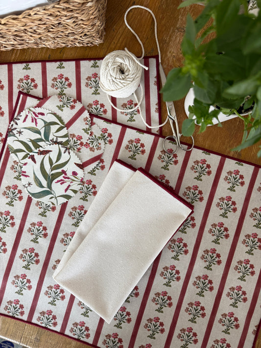 Set de servilletas crema con ribete granate